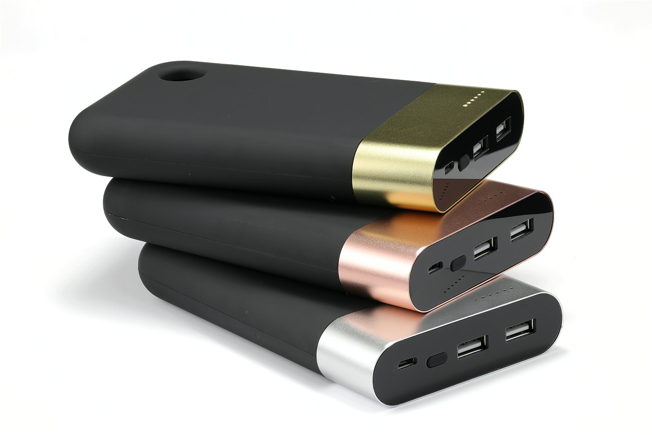 Three large black power banks with metal bands silver, gold and copper colour