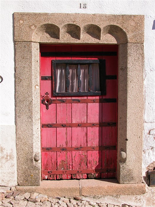 Red door with a carved granite surround in Marvao
